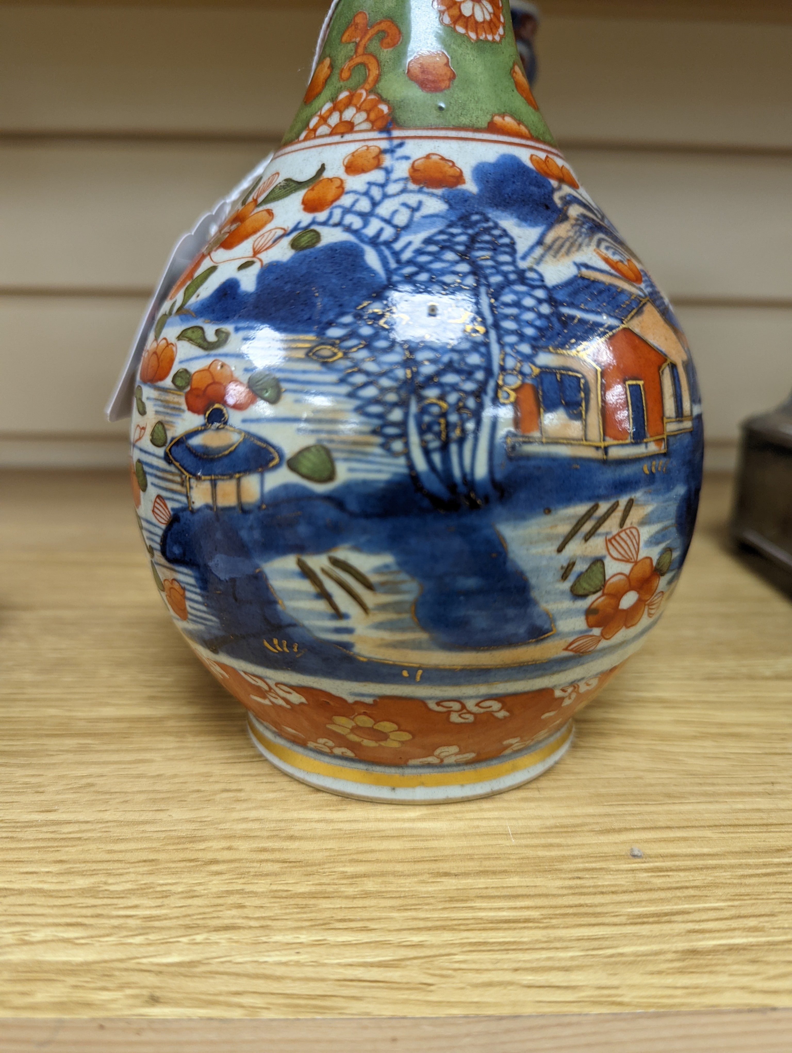 A pair of 18th century Chinese clobbered blue and white bottle vases 23cm